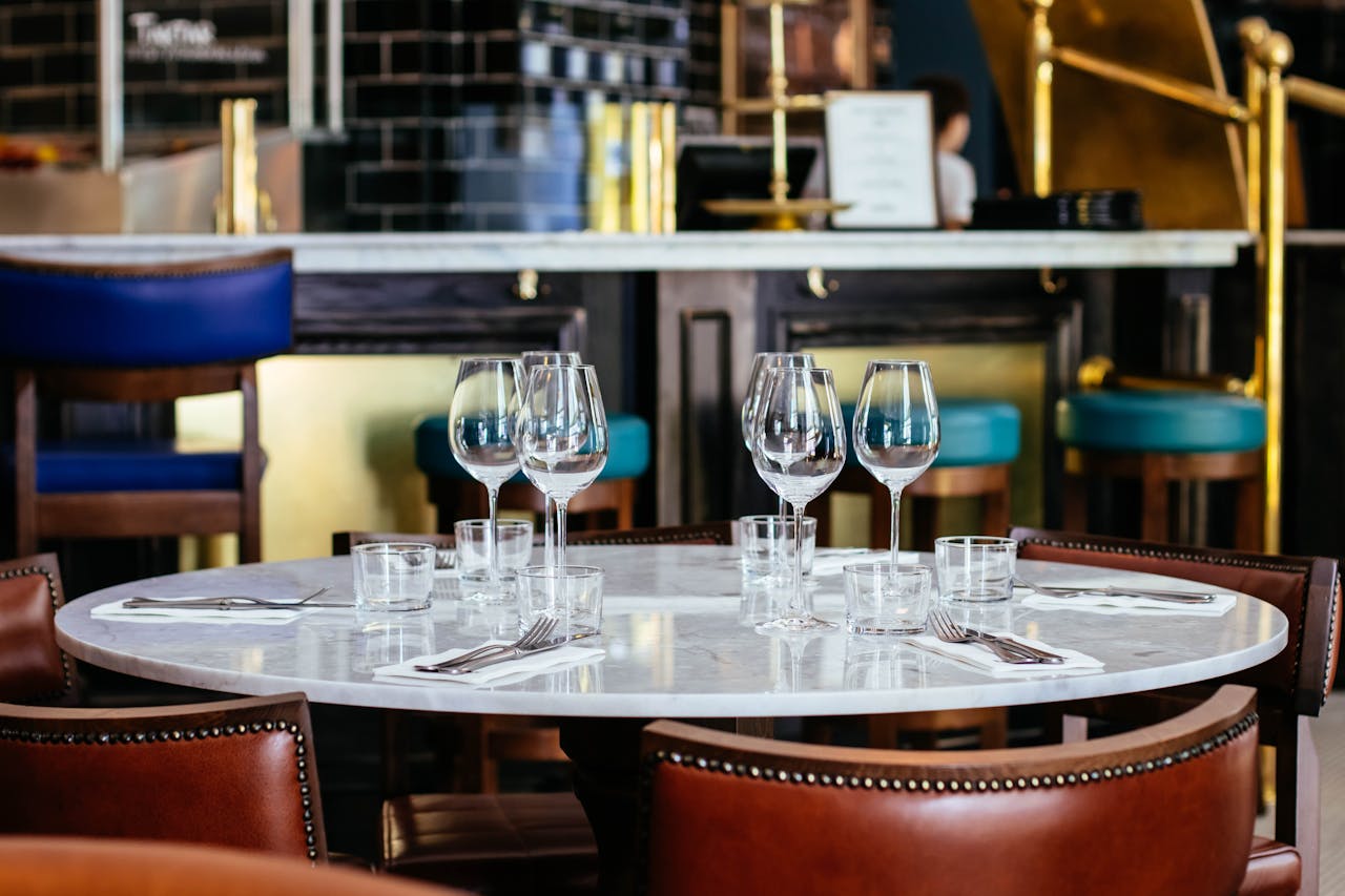 A sophisticated restaurant table arrangement with wine glasses and cutlery, awaiting guests.