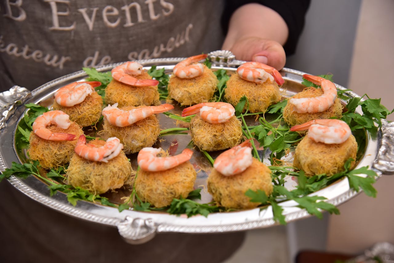 Delicious shrimp appetizers served elegantly on a silver platter with fresh greens.
